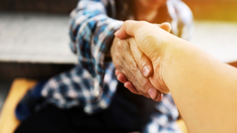 Close-up of a helping hand gesture symbolizing support in harm reduction or abstinence-based recovery