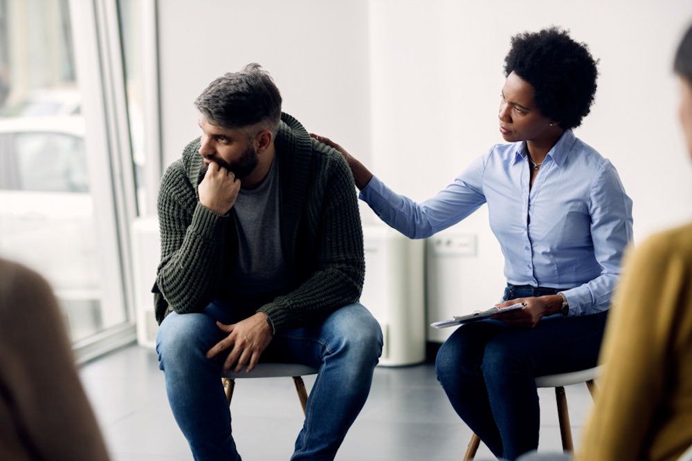 Therapist supporting patient in group session while discussing is kratom an opioid.